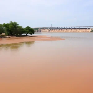 View of Lady Bird Lake with lowered water levels and dam in the background