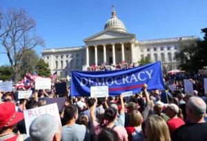 Crowd at the No Kings protest with signs advocating for democracy.