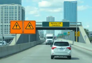 Oversized vehicle approaching Houston Avenue bridge under warning signs